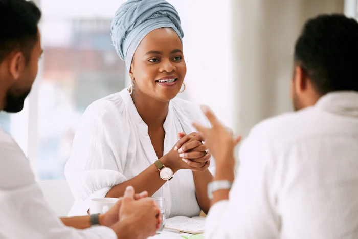 Business woman listening intently to two colleagues