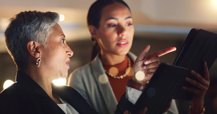 Female leader mentoring younger female team member, helping her to develop her career.