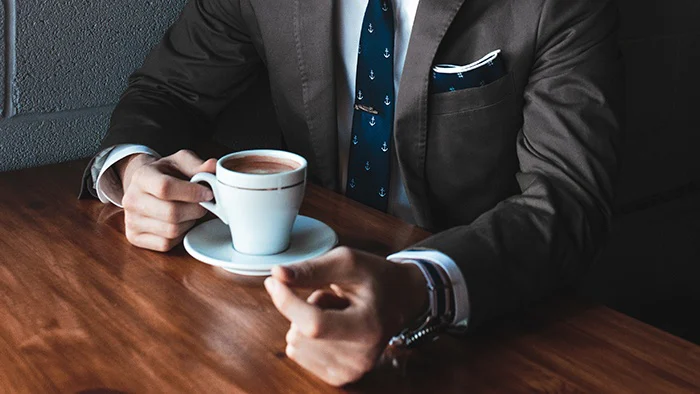 Man drinking coffee at a table